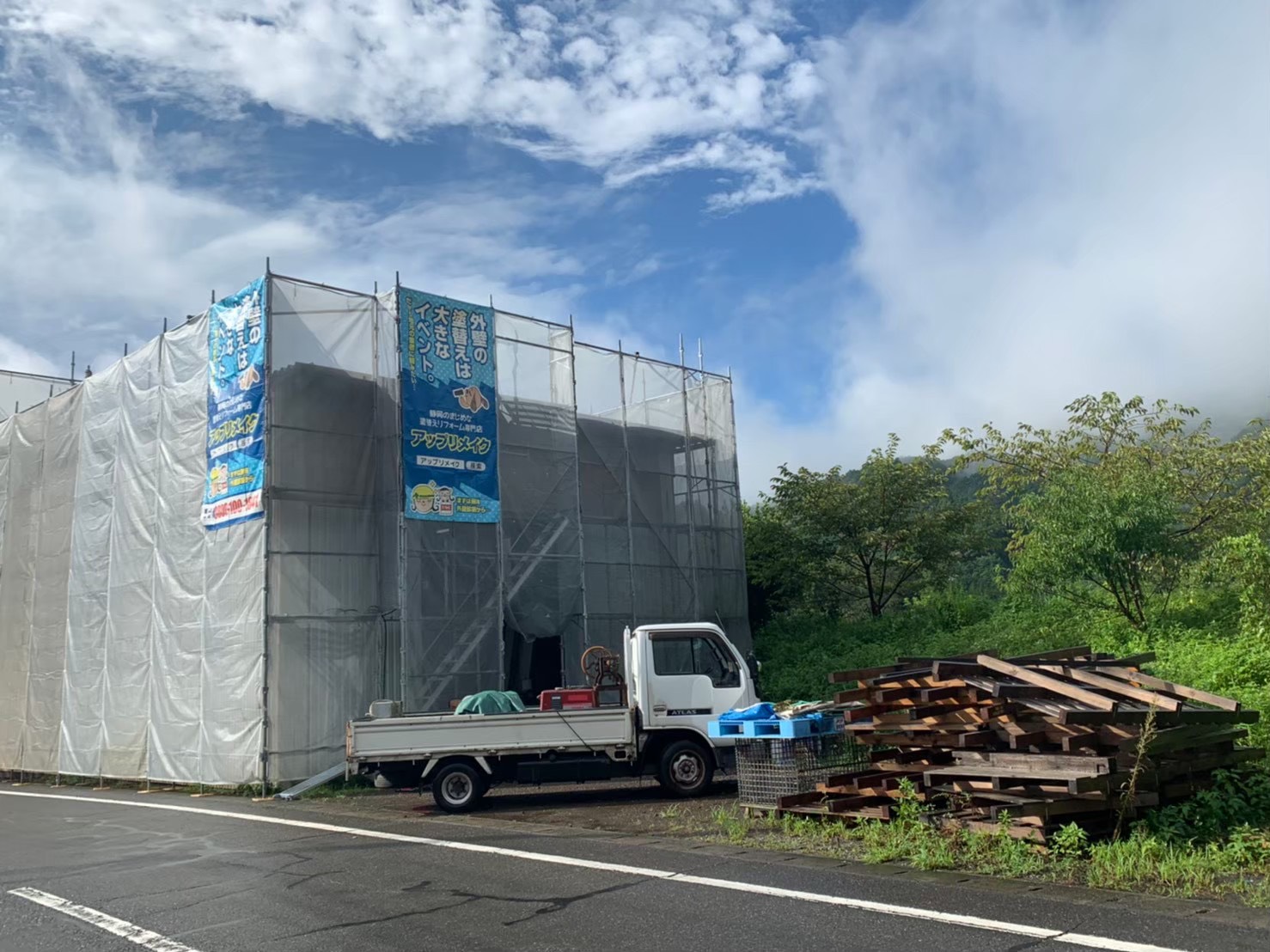 外壁塗装のために足場と飛散防止シートを設置した建物