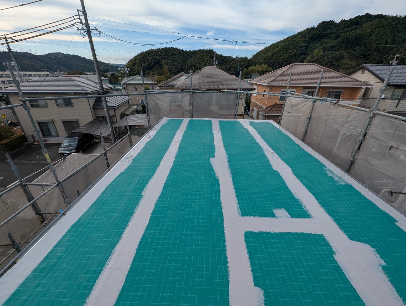 陸屋根に補強メッシュを敷き込んでいる様子