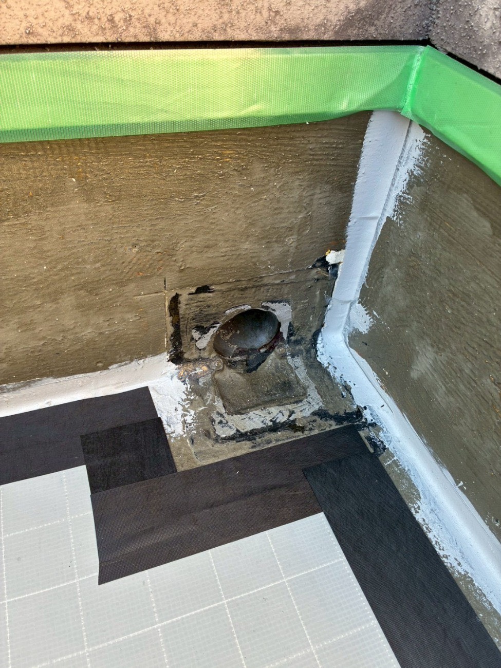 屋上の排水口(ドレン)まわりの下地を補修している様子