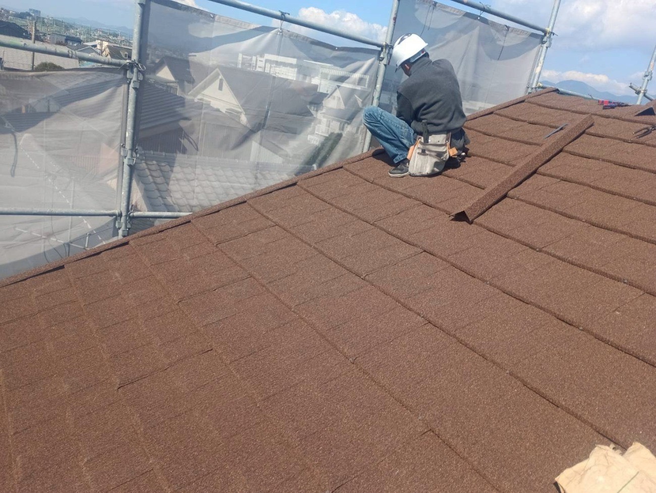 職人が屋根の上でセネター屋根材を施工している様子