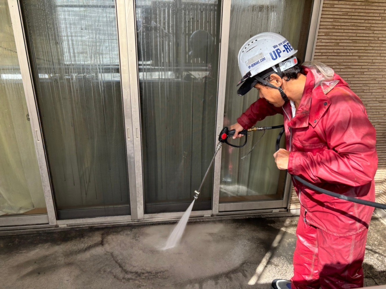 ベランダの床を高圧洗浄している様子