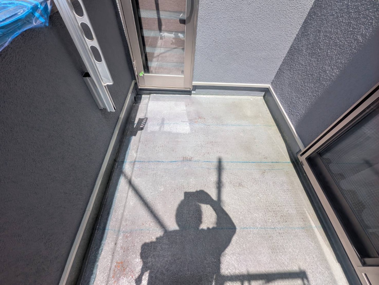 戸建て住宅のベランダでFRP防水の施工を進めている様子
