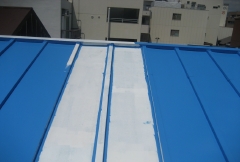 シリコン樹脂塗料を塗っている途中の屋根。