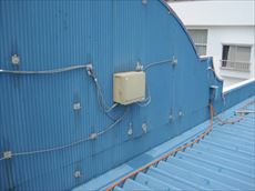 建物背面の青い壁に取り付けられた電飾の配線と機器