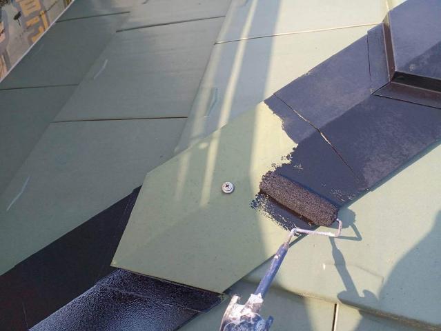 棟板金に黒い錆止めを塗っています