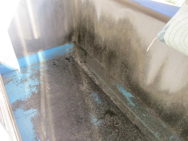 緑色の塗装がはがれ、下地が見えていたベランダ